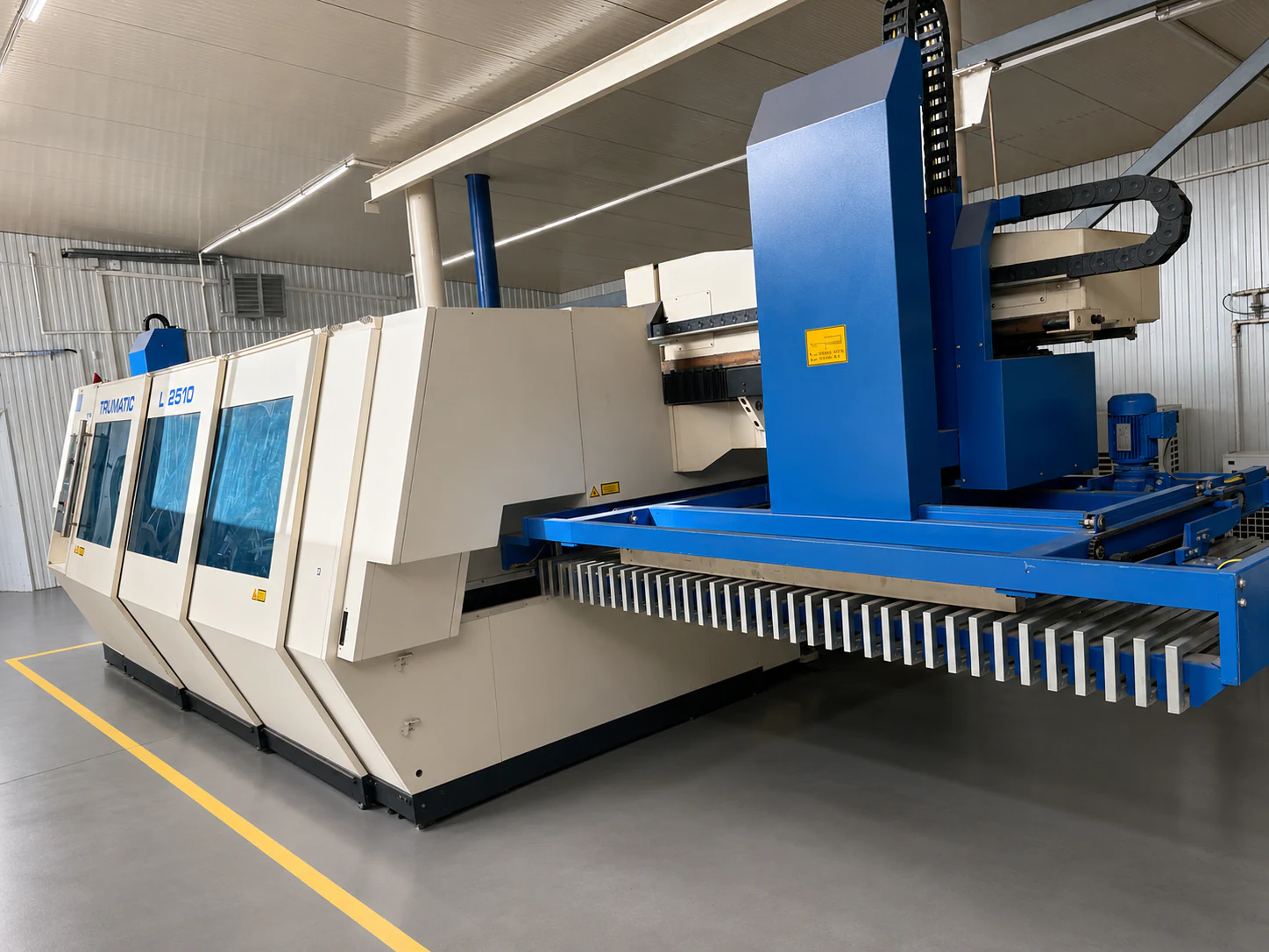 Utilaj de debitare laser CNC TRUMPF TRUMATIC L 2510 cu masă de încărcare automată, în hala de producție UtilajModern