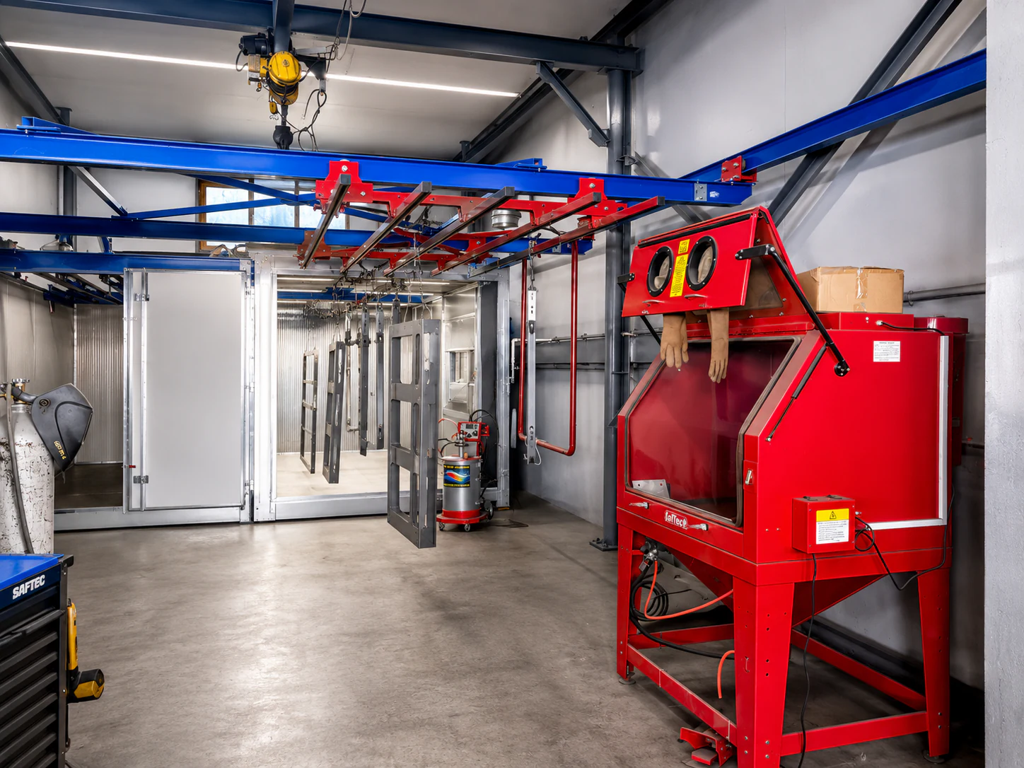 Linia de vopsire electrostatică din atelierul UtilajModern: conveior aerian, cabină de vopsire, cuptor de polimerizare și cabină de sablare